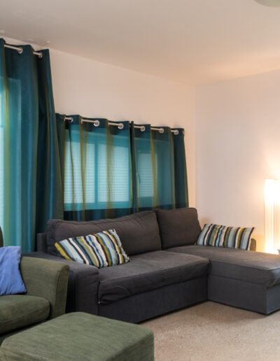 Wohnzimmer mit Schlafcouch und Sessel